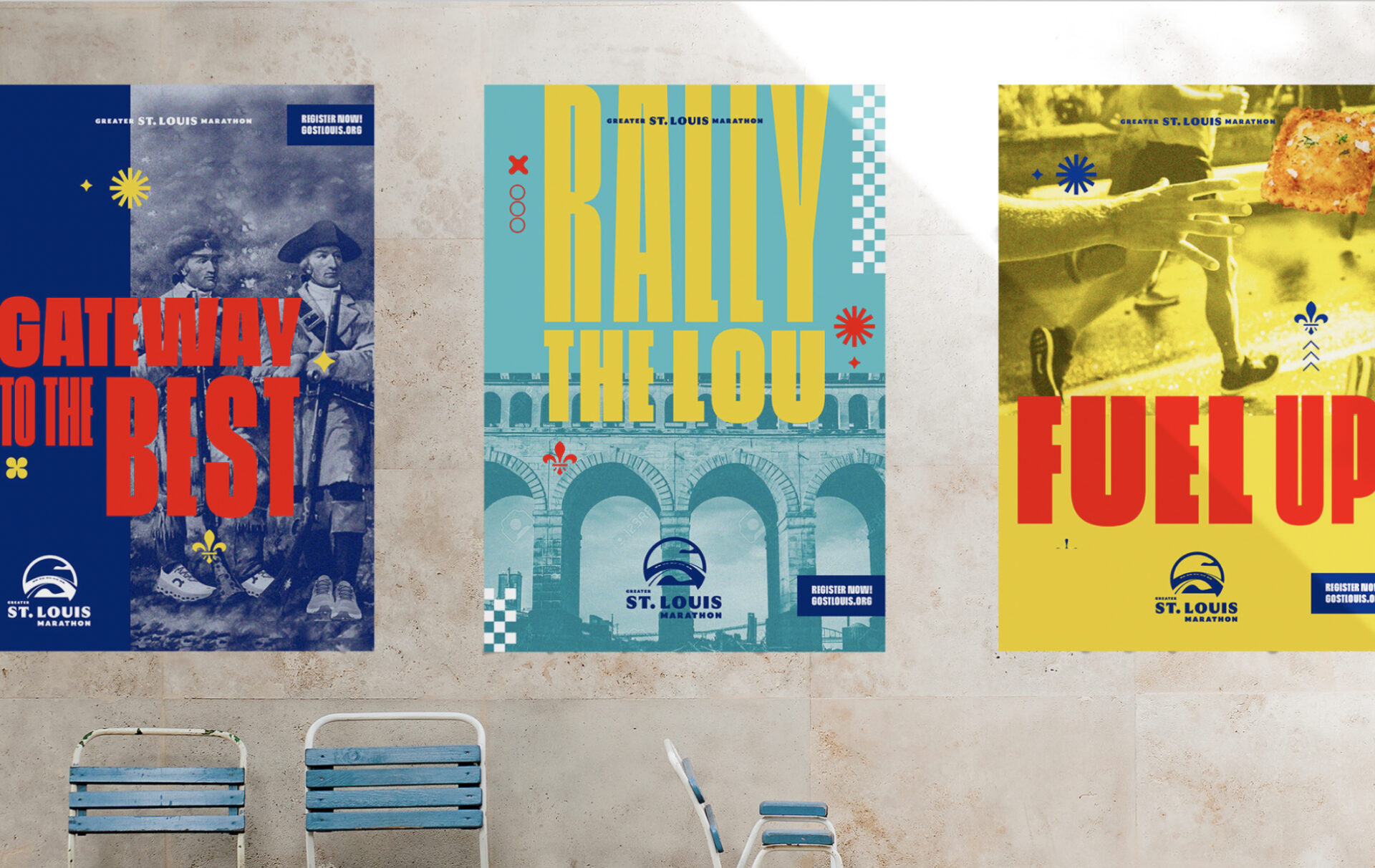 Three colorful tourism posters for St. Louis are displayed on a wall above two blue chairs. The posters read: Gateway to the Best, Rally the Lou, and Fuel Up, each with bold graphics and images.