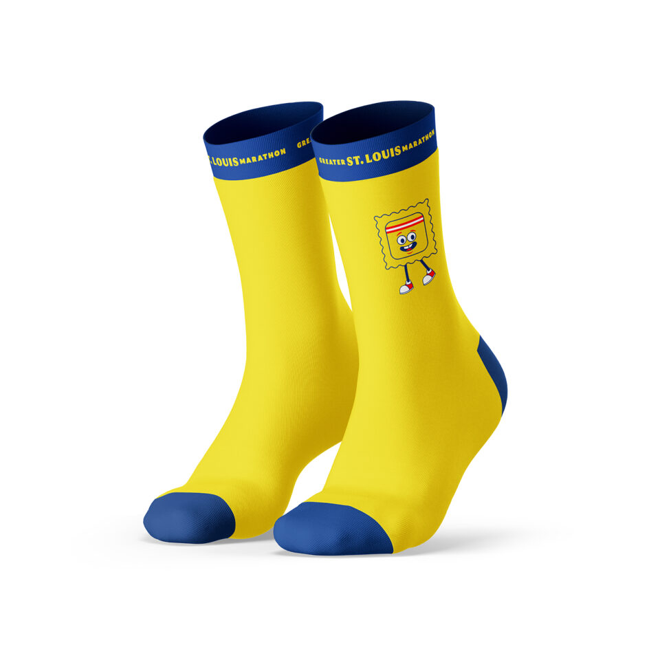 A pair of yellow socks with blue toes, heels, and cuffs featuring the text GO! ST. LOUIS MARATHON at the top and a cartoon ravioli character with arms, legs, and a smiling face on the side.