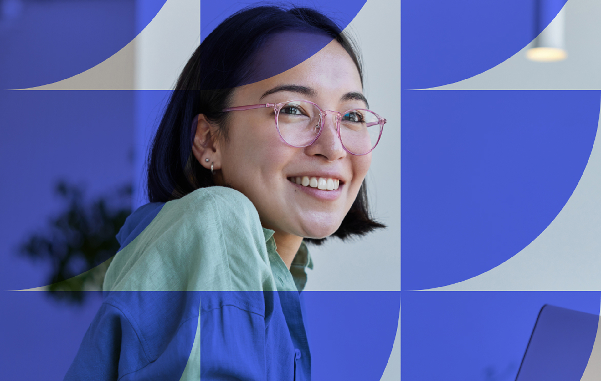A woman with short dark hair and glasses smiles at the camera. She wears a green and blue shirt. The image has a blue geometric overlay of semi-circles and shapes across it.