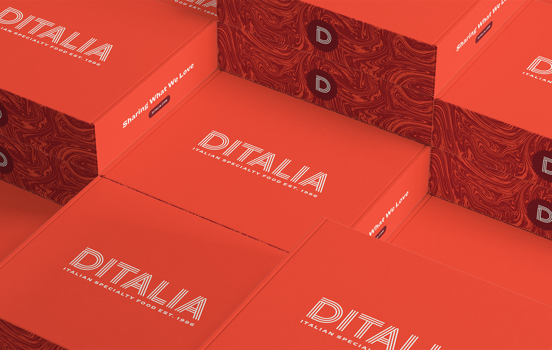 Several stacked red boxes feature the word “DITALIA” and “Italian specialty foods est. 1996” in white text. Some box sides display a marbled pattern, the letter “D,” and the phrase “Share What You Love.”.