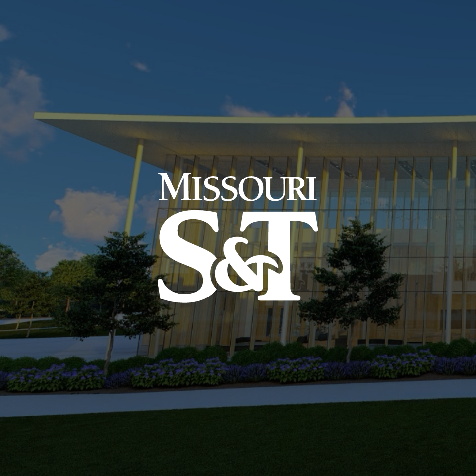 Modern building with large glass windows and trees in front, overlaid with the Missouri S&T logo in bold white letters.