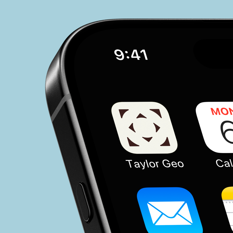 taylor-geospatial-app-icon - Sprehe Studio Close-up of a smartphone screen showing the top left corner with the time 9:41, a Taylor Geo app icon, part of a calendar app with MON 6, and a mail app icon on a light blue background.